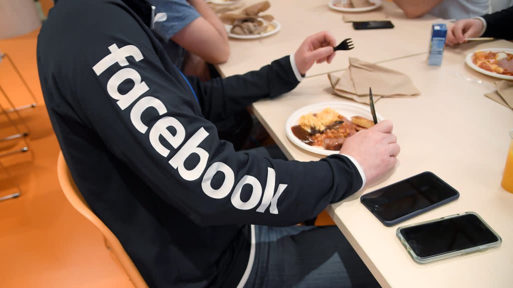 A man wearing a branded sweatshirt eats at Facebook's headquarters in London