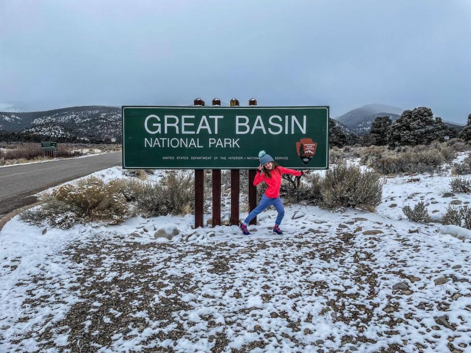 child standing in front of great basin sign