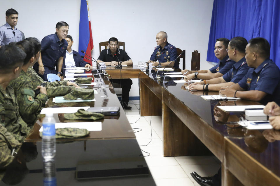 In this photo provided by the Presidential Malacanang Palace on Saturday July 20, 2019, Philippine President Rodrigo Duterte presides over a command conference with the officers of the Armed Forces of the Philippines and Philippine National Police during his visit to the wake of slain officers at Camp Lt. Col. Francisco C. Fernandez Jr. in Sibulan, Negros Oriental, in Central Philippines. On Thursday, July 25, 2019, President Rodrigo Duterte said he raised a reward of 3 million pesos ($59,000) out of anger for what he described as the Islamic State group-style killings of the officers on July 18 in Negros Oriental province. Communist guerrillas claimed responsibility for the attack but denied torturing the police officers. (Ace Morandante/Presidential Photo Via AP)