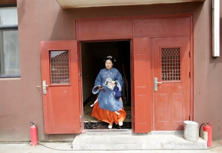Li Doudou, dressed in "Hanfu", leaves an apartment block for a performance of the "guqin" traditional musical instrument, in Hebei province, China