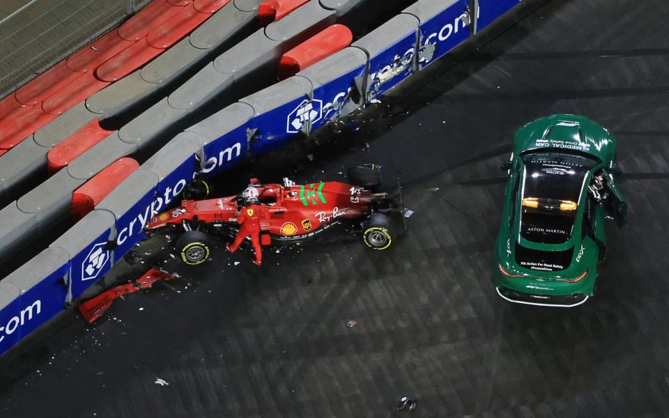 Ferrari&#39;s Monegasque driver Charles Leclerc stands next to his car after crashing during the second practice session of the Saudi Arabian Grand Prix at the Jeddah Corniche Circuit in Jeddah on December 3, 2021 - GIUSEPPE CACACE/AFP via Getty Images