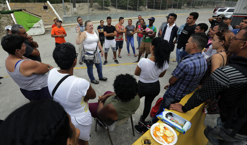 In this Tuesday, April 30, 2019, photo, attorney Jodi Goodwin, center, speaks to migrants seeking asylum near the international bridge in Matamoros, Mexico. Goodwin explained to them what would happen to them when they entered U.S. custody. (AP Photo/Eric Gay)