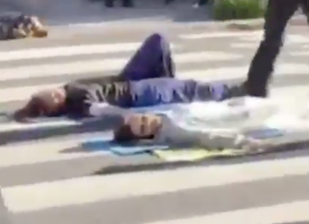 Adani protestors pictured stuck to a crosswalk in Brisbane. 