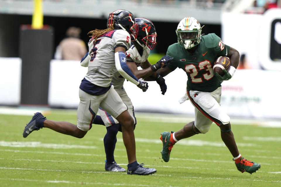 Jackson State cornerbacks Ke'Vric Wiggins Jr. (5) and Anthony Petty (24) defend as Florida A&M running back Terrell Jennings (23) runs during the first half of the Orange Blossom Classic NCAA college football game, Sunday, Sept. 3, 2023, in Miami Gardens, Fla. (AP Photo/Lynne Sladky)