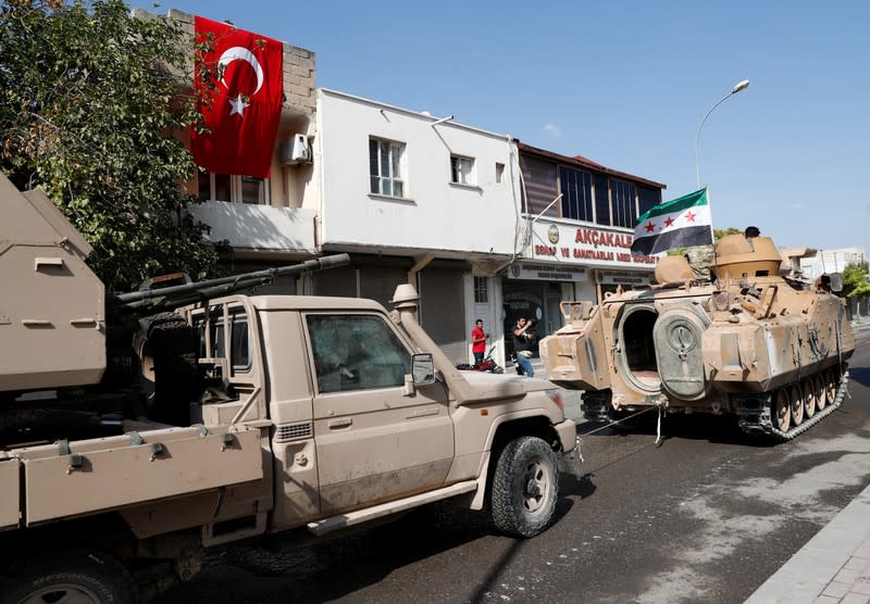 Turkey-backed Syrian rebel fighters return from the Syrian border town of Tal Abyad