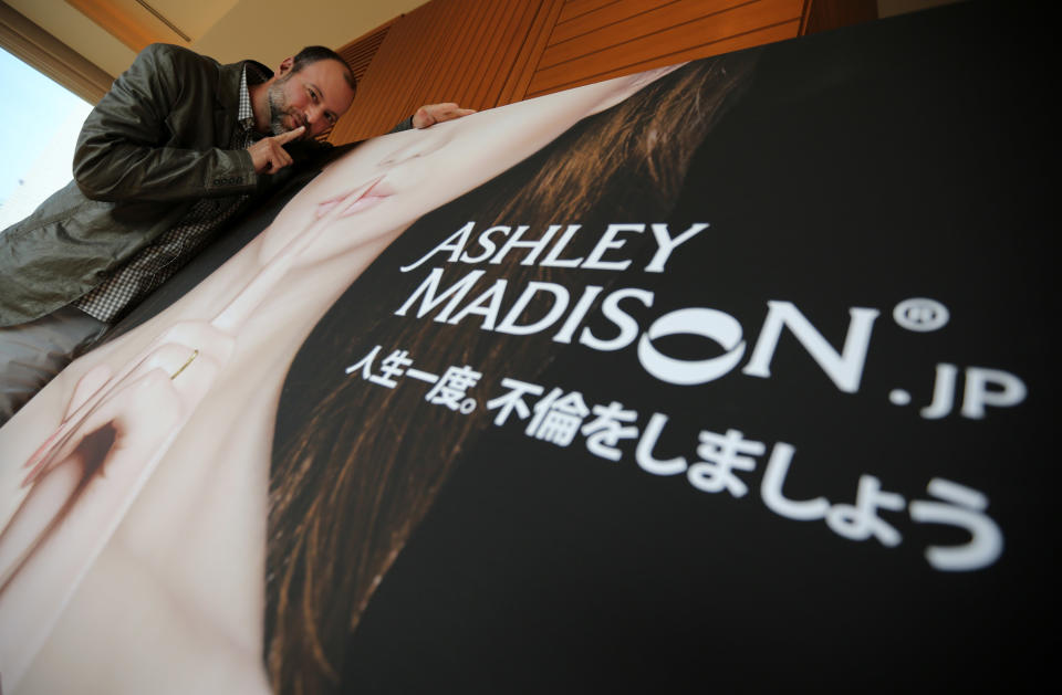 In this Tuesday, April 1, 2014 photo, Noel Biderman, chief executive of Avid Life Media Inc., which operates AshleyMadison.com., poses during a photo session in Tokyo. Ashley Madison, the world’s biggest online hookup site for married people, works only when monogamy is the rule on the surface but, deep inside, couples want to cheat. That’s why it is scoring big in Japan. Its slogan written in Japanese on the panel reads: “Life is short. Have an affair.” (AP Photo/Eugene Hoshiko)