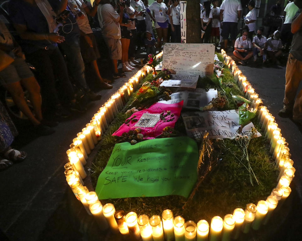 A few hundred people gathered around a median with candles, flowers and posters outside Miya Marcano's apartment during a vigil for the 19-year-old at Arden Villas, Friday, Oct. 1, 2021, in Orlando, Fla. Orange County Sheriff John Mina said Saturday that authorities found Marcano’s body near an apartment building. Marcano vanished on the same day a maintenance man improperly used a master key to enter her apartment. (Chasity Maynard/Orlando Sentinel via AP)