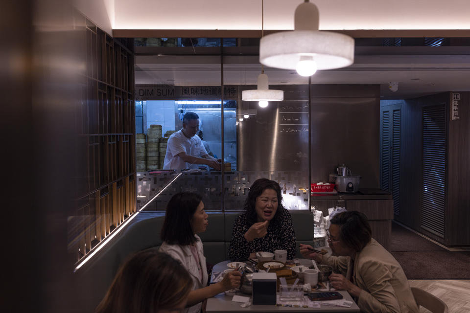 Mak Kwai-pui, rear left, co-founder of dim sum chain Tim Ho Wan, prepares dim sum to serve as customer eat at a branch of his restaurant in Hong Kong, Thursday, April 27, 2023. Living in Hong Kong today means juggling contradictory feelings. In 20 interviews, many said that when they focus on business indicators and everyday life, they see a recovery gathering pace after years of travel restrictions. But when it comes to anything political, the openness and freedoms that were once hallmarks of the Chinese-ruled former British colony seem permanently gone. (AP Photo/Louise Delmotte)