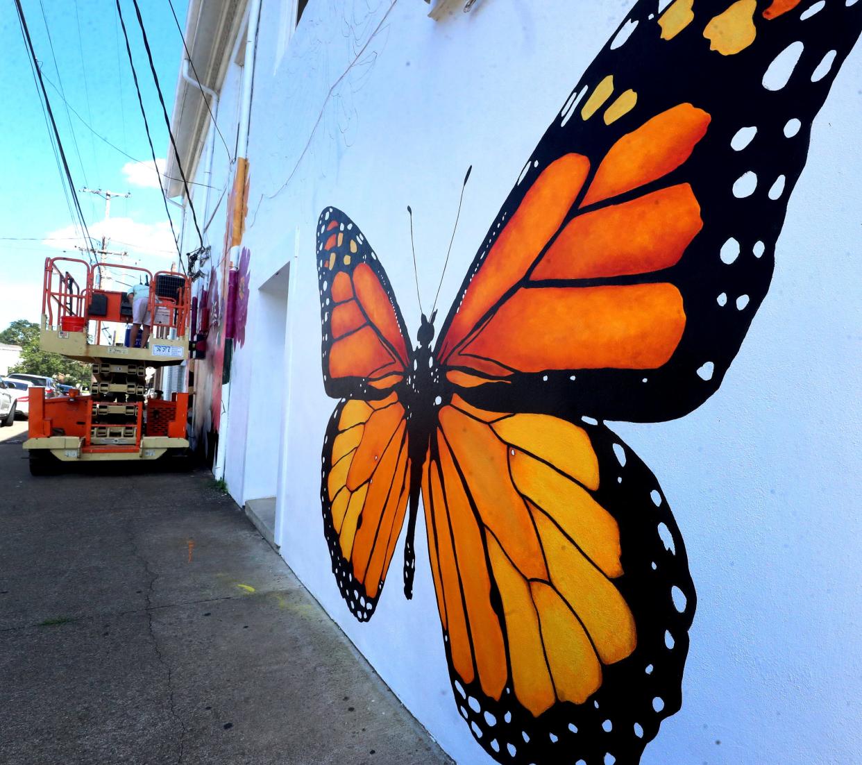 A large monarch butterfly is part of a new mural being painted by The Experience Community Church in downtown Murfreesboro one the corner of West College Street and North Church Street on Monday, July 31, 2023. The butterfly was designed so passersby can use it as a winged photo opt.