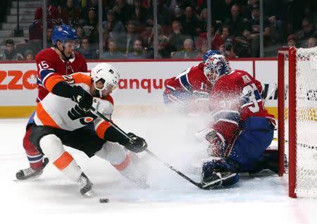 Jan 19, 2019; Montreal, Quebec, CAN; Montreal Canadiens goaltender Antti Niemi (37) makes a save against Philadelphia Flyers center Scott Laughton (21) as center Jesperi Kotkaniemi (15) defends during the second period at Bell Centre. Mandatory Credit: Jean-Yves Ahern-USA TODAY Sports