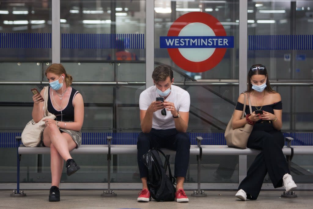 Commuters wait for a tube on the London Underground in July this year (Getty Images)