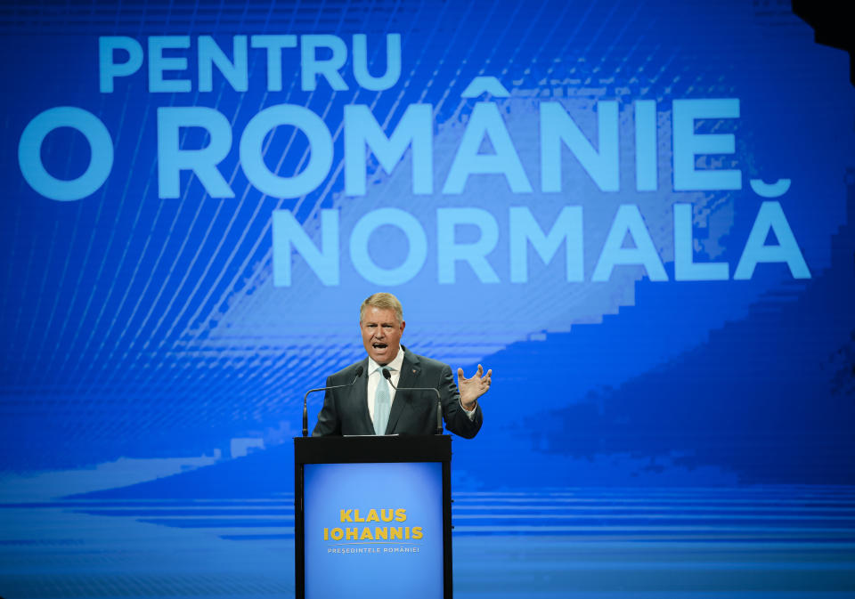 FILE- In this Thursday, Aug. 8, 2019, file picture, Romanian President Klaus Iohannis waves to supporters during the National Council of the Liberal Party in Bucharest, Romania. Romania’s presidential election scheduled for Nov. 10, has been overshadowed by the recent political crisis which led to the fall of the Social Democratic government. Text on screen reads "For a Normal Romania". (AP Photo/Vadim Ghirda, File)
