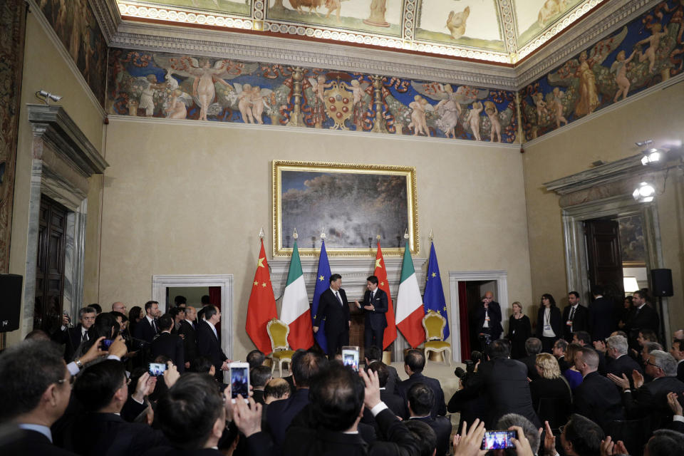 Chinese President Xi Jinping, background left, meet with Italian Premier Giuseppe Conte during the signing ceremony of a memorandum of understanding at Rome's Villa Madama, Saturday, March 23, 2019. Italy signed a memorandum of understanding with China on Saturday in support of Beijing's "Belt and Road" initiative, which aims to weave a network of ports, bridges and power plants linking China with Africa, Europe and beyond. (AP Photo/Andrew Medichini)