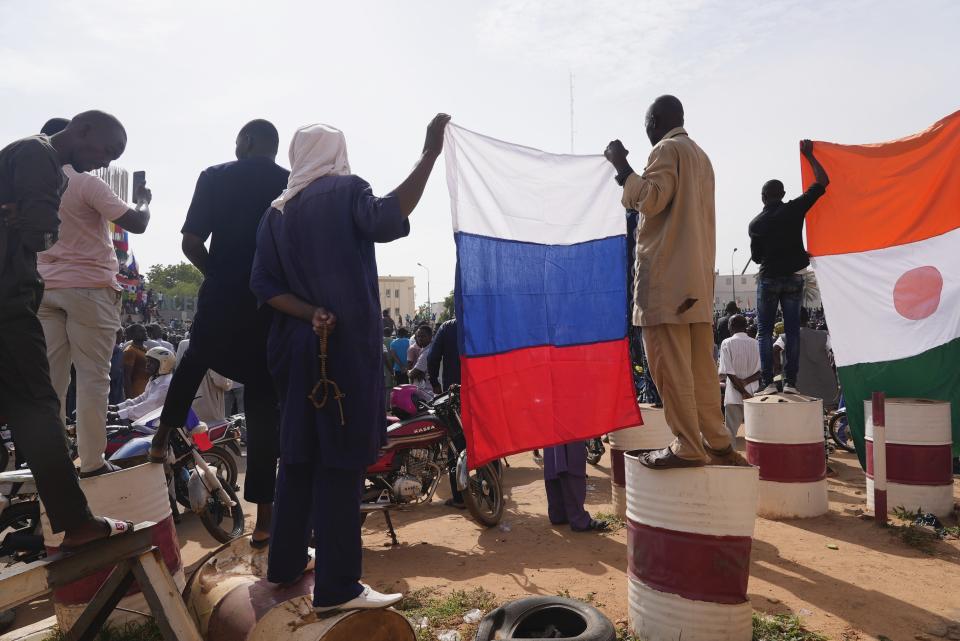 Nigeriens holding a Russian flag participate in a march called by supporters of coup leader Gen. Abdourahmane Tchiani in Niamey, Niger, Sunday, July 30, 2023. Days after after mutinous soldiers ousted Niger's democratically elected president, uncertainty is mounting about the country's future and some are calling out the junta's reasons for seizing control. (AP Photo/Sam Mednick)
