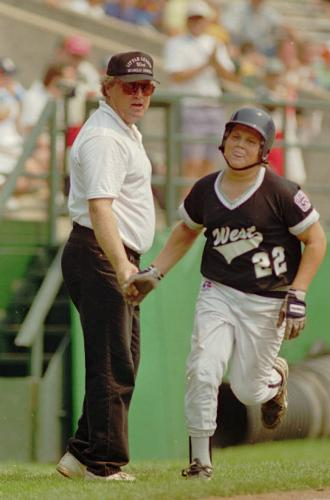 Long Beach, Ca., Little League coach Jeff Burroughs congratulates his son Sean as he rounds third base.