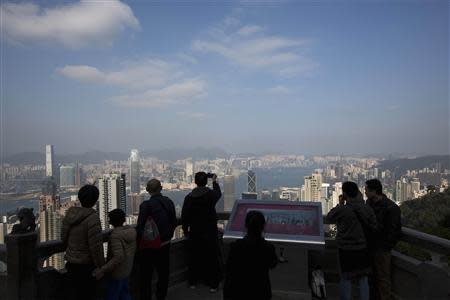 Mainland Chinese tourists view the Hong Kong skyline at the Peak in Hong Kong January 14, 2014. REUTERS/Tyrone Siu