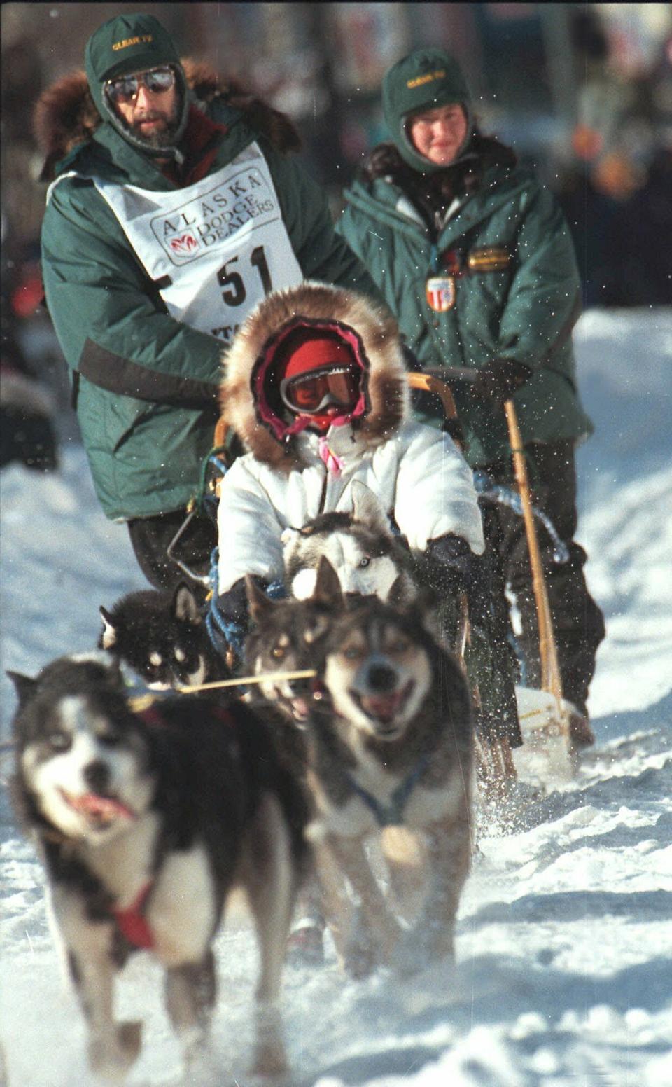 FILE - In this March 6, 1999, file photo, soap opera star Susan Lucci takes a ride in the sled of musher Rick Mackey at the start of the 27th Iditarod Trail Sled Dog Race in Anchorage, Alaska. Mackey, the winner of the 1983 Iditarod Trail Sled Dog Race, has died of lung cancer, his daughter Brenda told The Associated Press, Wednesday, May 11, 2024. Mackey, who died Monday, May 13, was 71. (AP Photo/Al Grillo, File)