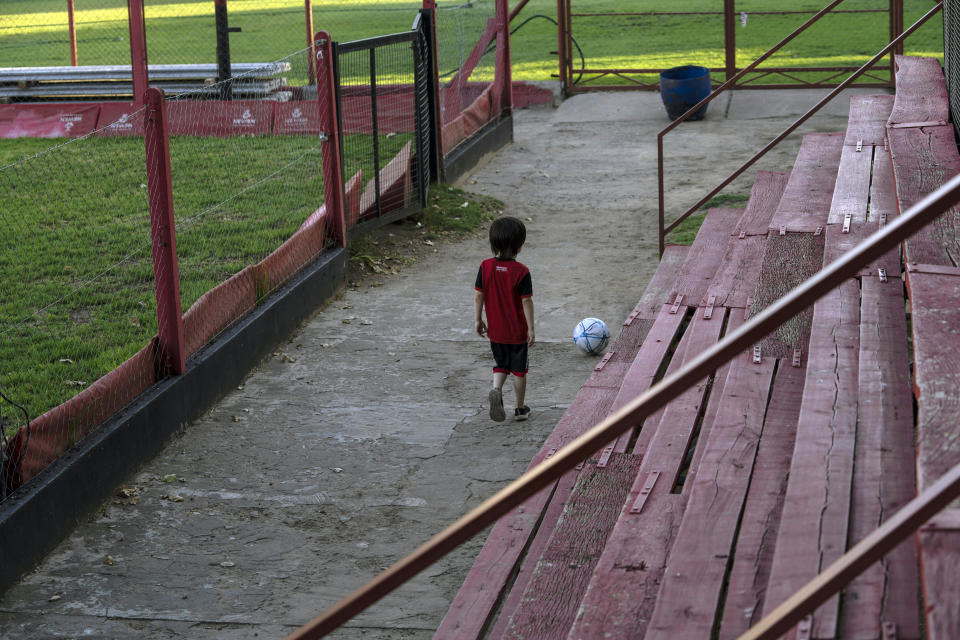 A boy plays with a ball during training at a football school at Newell's All Boys club, where Lionel Messi played as a kid in Rosario, Argentina, Wednesday, Dec.14, 2022. (AP Photo/Rodrigo Abd)