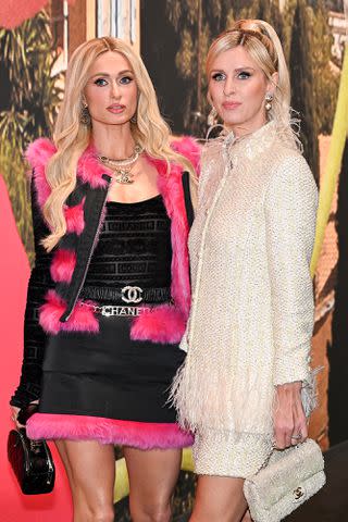 <p>BERTRAND GUAY/AFP via Getty</p> Paris Hilton (left) and her sister Nicky Hilton