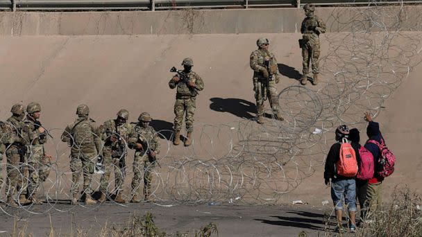 PHOTO: Migrants seeking asylum in the United States ask Texas National Guard agents to let them turn themselves in with Border Patrol agents in the El Paso, Texas border with Ciudad Juarez, Chihuahua state, Mexico, Dec. 20, 2022. (Herika Martinez/AFP via Getty Images)