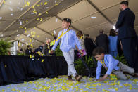 Kids play in confetti at the groundbreaking ceremony for a high-speed railway on Monday, April 22, 2024, in Las Vegas. A $12 billion high-speed passenger rail line between Las Vegas and the Los Angeles area has started construction. (AP Photo/Ty ONeil) (AP Photo/Ty ONeil)