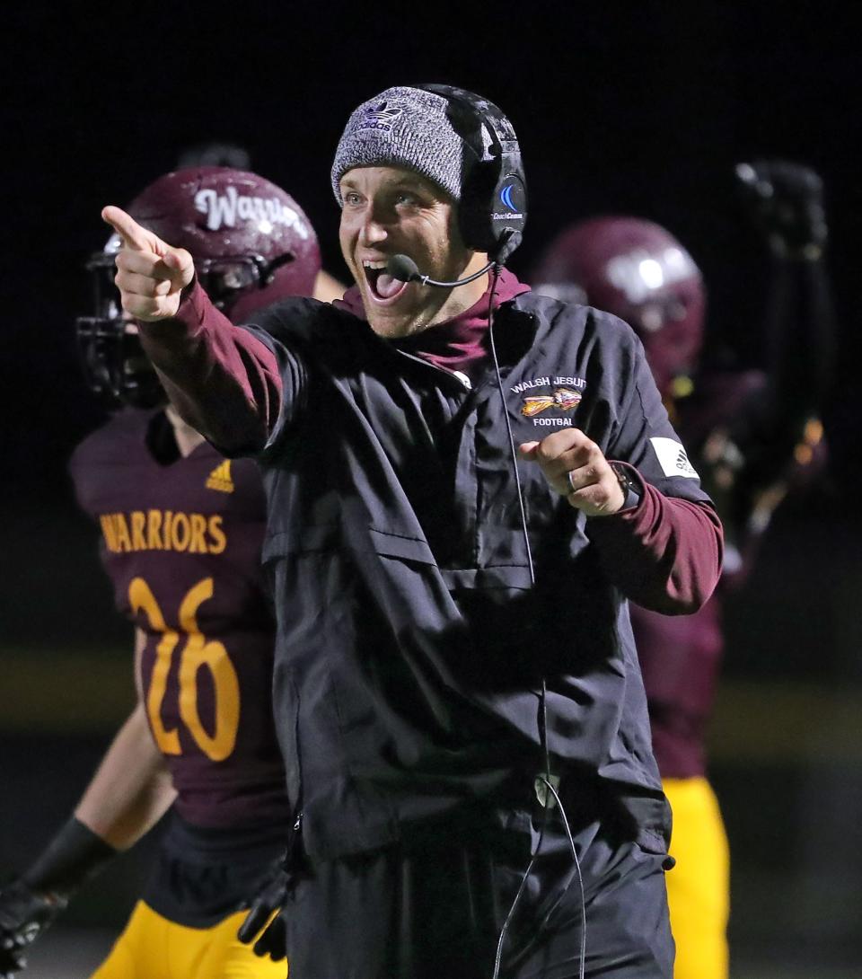 Walsh Jesuit football coach Nick Alexander congratulates his team after a touchdown against Mentor Lake Catholic on Oct. 7, 2022.