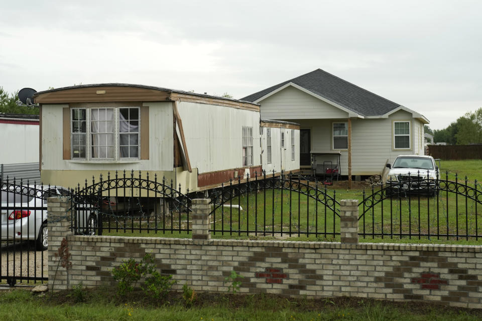 A mobile home sits in front of home in the Colony Ridge development Tuesday, Oct. 3, 2023, in Cleveland, Texas. The booming Texas neighborhood is fighting back after Republican leaders took up unsubstantiated claims that it has become a magnet for immigrants living in the U.S. illegally and that cartels control pockets of the neighborhood. (AP Photo/David J. Phillip)