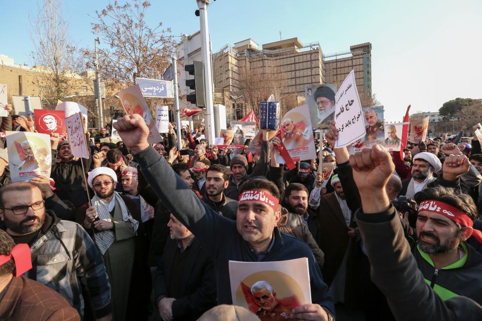 Iranian demonstrators hold placards bearing the images of slain military commander Qasem Soleimani and Iran's Supreme Leader Ayatollah Ali Khamenei in front of the British embassy in the capital Tehran on January 12, 2020 following the British ambassador's arrest for allegedly attending an illegal demonstration. - Chanting "Death to Britain", up to 200 protesters rallied outside the mission a day after the brief arrest of British ambassador Rob Macaire at a memorial for those killed when a Ukraine airliner was shot down. (Photo by ATTA KENARE / AFP) (Photo by ATTA KENARE/AFP via Getty Images)