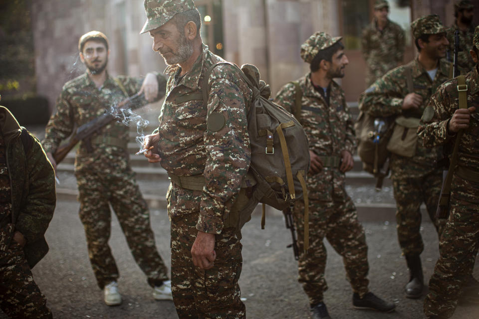 FILE - In this Sept. 29, 2020, file photo, ethnic Armenian volunteer recruits gather to receive their uniforms and weapons before being dispatched to the frontline near Hadrut, in Nagorno-Karabakh, a predominantly Armenian region inside Azerbaijan. While separatist forces in Nagorno-Karabakh and in the Armenian military continue to rely mostly on aging Soviet-built weapons, Azerbaijan has completely revamped its arsenal with state-of-the-art attack drones and powerful long-range multiple rocket systems supplied by its neighbor and ally, Turkey. (AP Photo/Karen Mirzoyan, File)