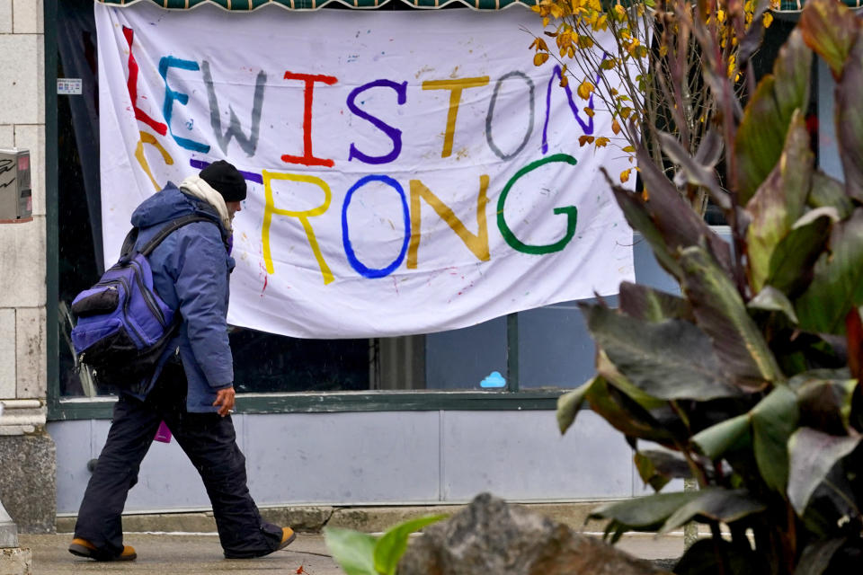 A man walks past a "Lewiston Strong" sign, Sunday, Oct. 29, 2023, in Lewiston, Maine. The community is working to heal following shooting deaths of 18 people at a bowling alley and a bar in Lewiston on Wednesday, Oct. 25. (AP Photo/Matt York)