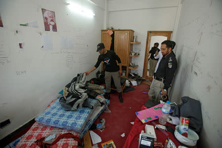 FILE PHOTO: Police search the dorm room of Mashal Khan, accused of blasphemy, who was killed by a mob at Abdul Wali Khan University in Mardan, Pakistan April 14, 2017. REUTERS/Fayaz Aziz/File Photo