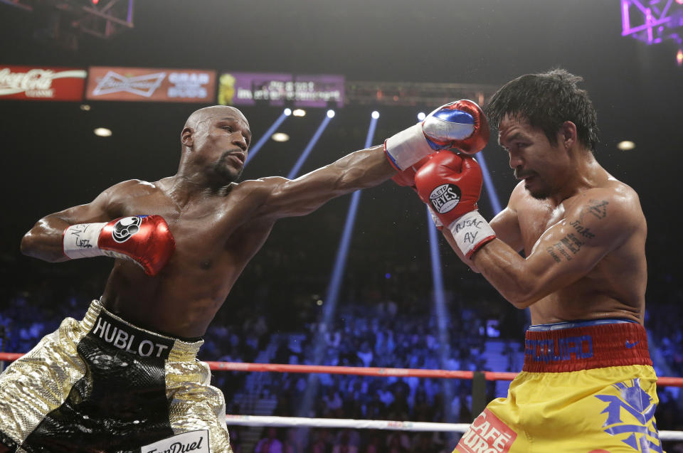 Floyd Mayweather Jr., left, trades blows with Manny Pacquiao, from the Philippines, during their welterweight title fight on Saturday, May 2, 2015 in Las Vegas. (AP Photo/Isaac Brekken)