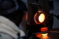 An employee pours liquid gold into a mould for the production of an ingot during the refining process at AGR (African Gold Refinery) in Entebbe