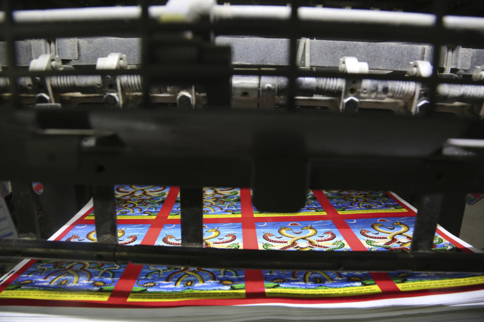 In this Aug. 2, 2019, photo, machine printed posters get ready ahead of Naag panchami festival at a printing press in Kathmandu, Nepal. The art and tradition of Nepal’s Chitrakar families, who depicted gods and goddesses on temples, masks of Hindu deities and posters for various religious celebrations is dying because of mass machine printed posters and card-size pictures of gods that are cheaper and more popular. (AP Photo/Niranjan Shrestha)