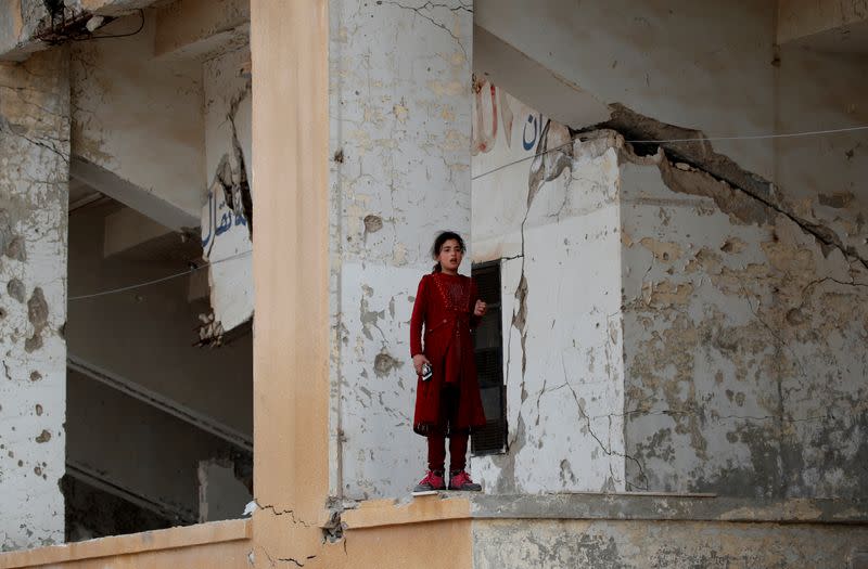 FILE PHOTO: An internally displaced Syrian girl stands and observes in an IDP camp located in Idlib