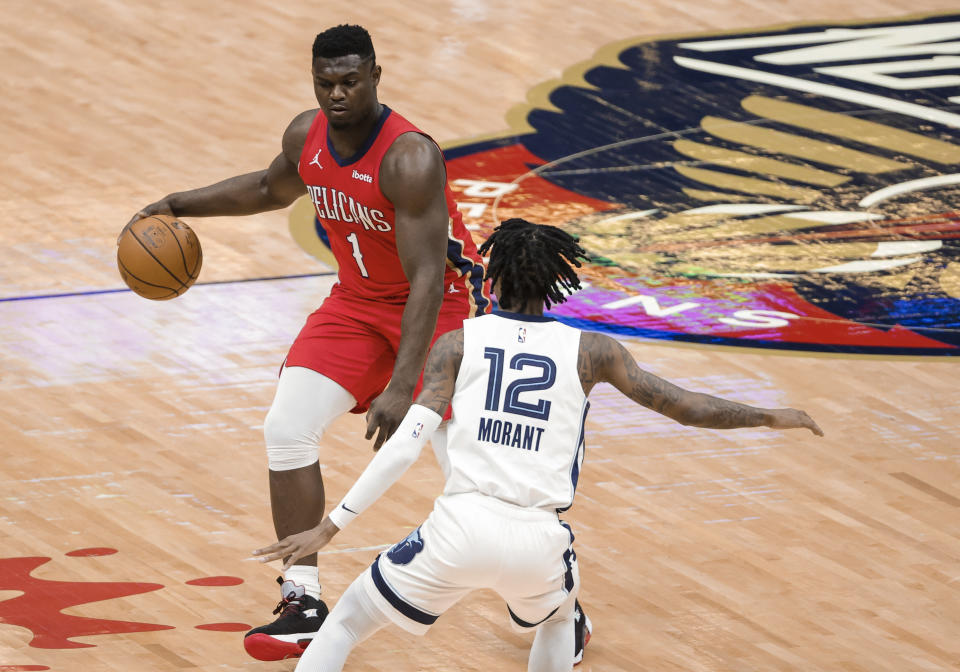 New Orleans Pelicans forward Zion Williamson (1) is defended by Memphis Grizzlies guard Ja Morant (12) during the first quarter of an NBA basketball game in New Orleans, Saturday, Feb. 6, 2021. (AP Photo/Derick Hingle)