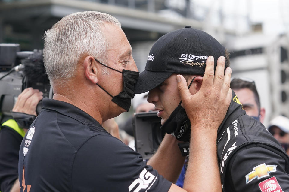 Marijn van Kalmthout talks with is son, Rinus VeeKay, of the Netherlands, during qualifications for the Indianapolis 500 auto race at Indianapolis Motor Speedway, Sunday, May 23, 2021, in Indianapolis. (AP Photo/Darron Cummings)