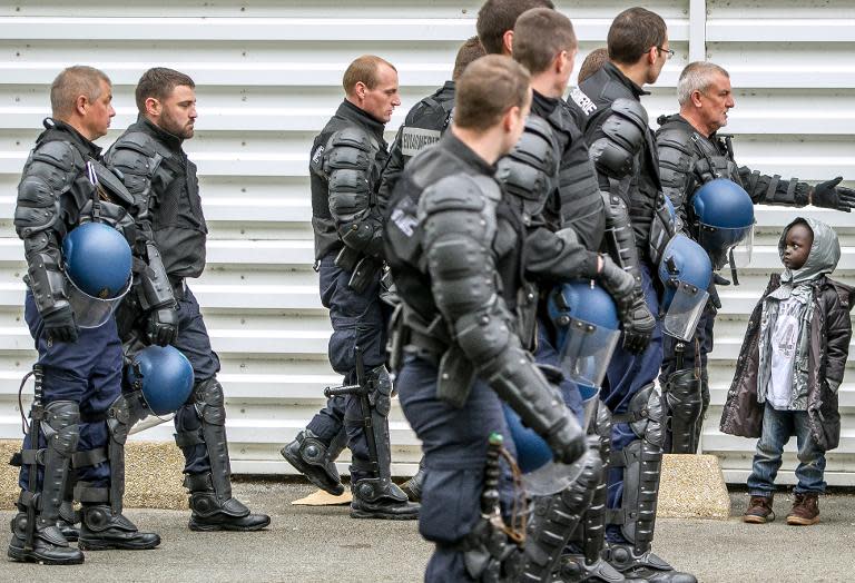 French gendarmes round up and evict migrants who were living in a camp near the Channel Tunnel in Calais on June 2, 2015