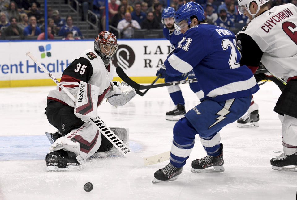 Arizona Coyotes goaltender Darcy Kuemper (35) deflects a shot as Tampa Bay Lightning center Brayden Point (21) looks for the rebound during the second period of an NHL hockey game Monday, March 18, 2019, in Tampa, Fla. (AP Photo/Jason Behnken)