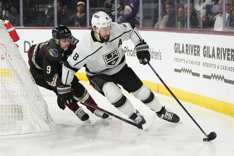 Los Angeles Kings defenseman Drew Doughty (8) shields the puck from Arizona Coyotes right wing Clayton Keller (9) in the second period during an NHL hockey game, Friday, Oct. 27, 2023, in Tempe, Ariz. (AP Photo/Rick Scuteri)