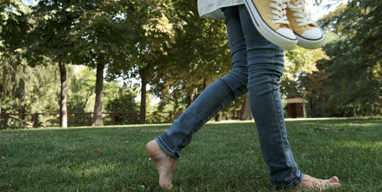 woman walking barefoot on grass