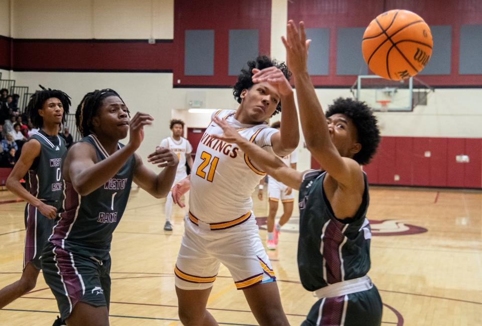 Edison's Arthur Grady Jr., center, fights for a rebound with Weston Ranch's Darrion Lilly, left, and Caleb Butler during a boys varsity basketball game at Edison in Stockton on Jan, 3, 2024.