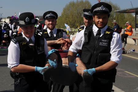 Foto del sábado de agentes de la policía deteniendo a un manifestante contra el cambio climático en el Puente Waterloo de Londres. Abr 20, 2019. REUTERS/Simon Dawson