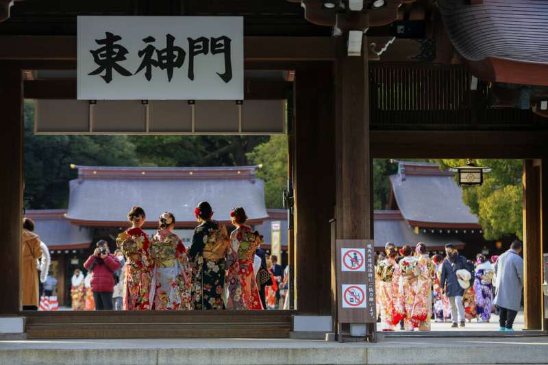 雖然新冠疫情肆虐，東京今年的成人式仍有部分地區維持舉辦，參加者盛裝打扮、戴著口罩出席。（美聯社）