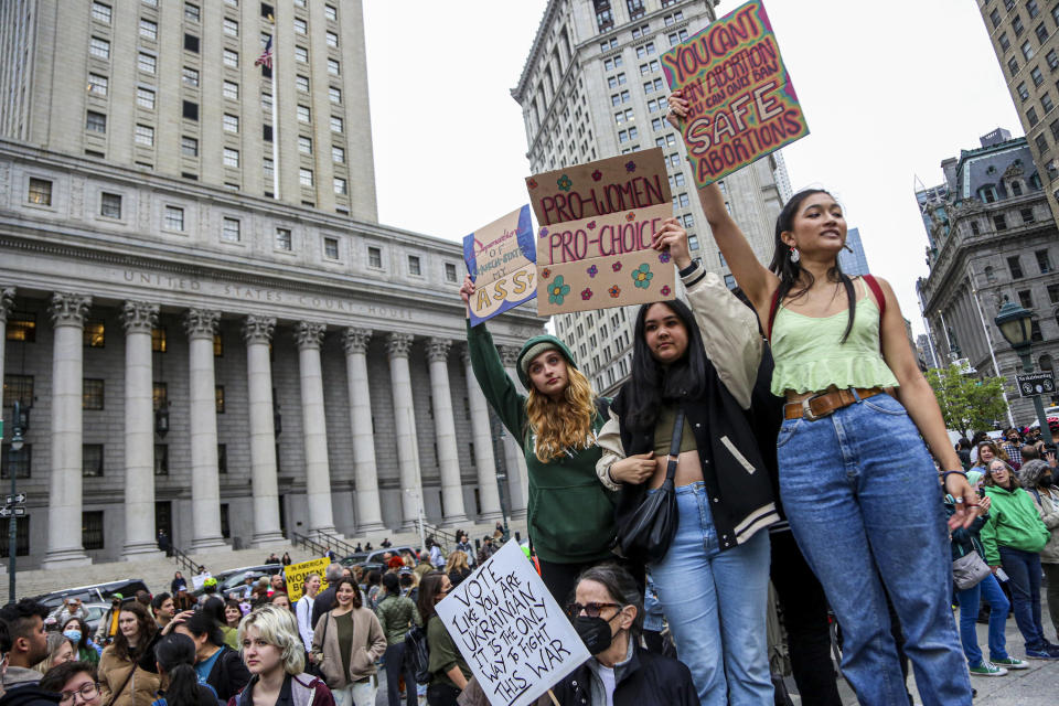 young women holding pro-abortion signs at a march