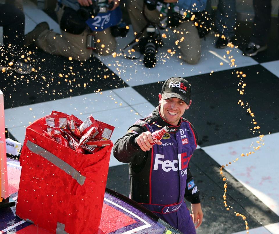 Denny Hamlin (11) celebrates in Victory Lane after winning a NASCAR Sprint Cup Series auto race at Watkins Glen International in 2016.