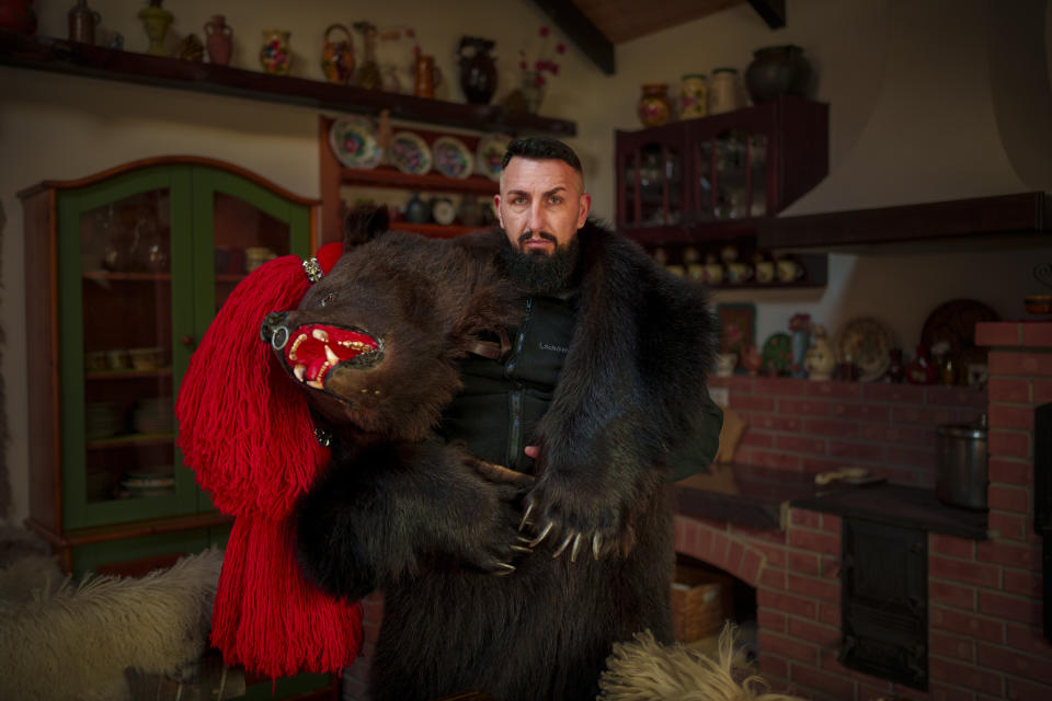Marian, 35 years-old, a member of the Sipoteni bear pack, poses for a portrait in Comanesti, northern Romania, Wednesday, Dec. 27, 2023. Marian first wore the bear fur costume when he was 6 years-old, never missed a festival since and hopes his children will take the unique tradition into the future. Marian says he would give up anything in live but not the dancing bear tradition. (AP Photo/Andreea Alexandru)