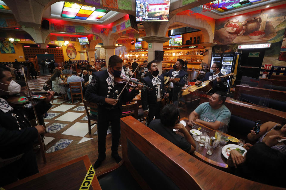 Mariachis perform for a group of revelers inside Salon Tenampa on Garibaldi Square, as nightlife returns amid the ongoing coronavirus pandemic, in Mexico City, Saturday, Aug. 22, 2020. (AP Photo/Rebecca Blackwell)
