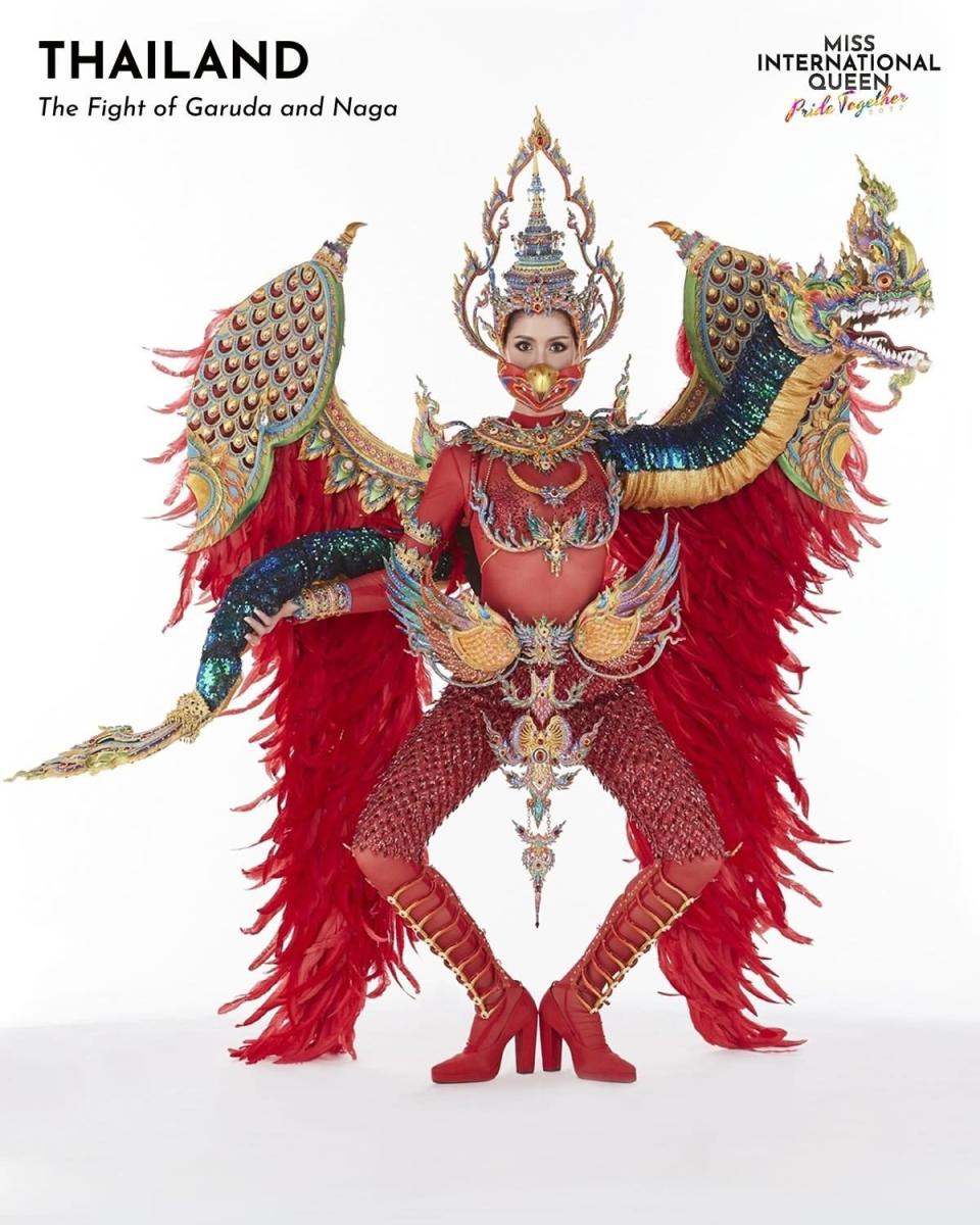 Miss Thailand in a red outfit with feathers and a decorative dragon piece