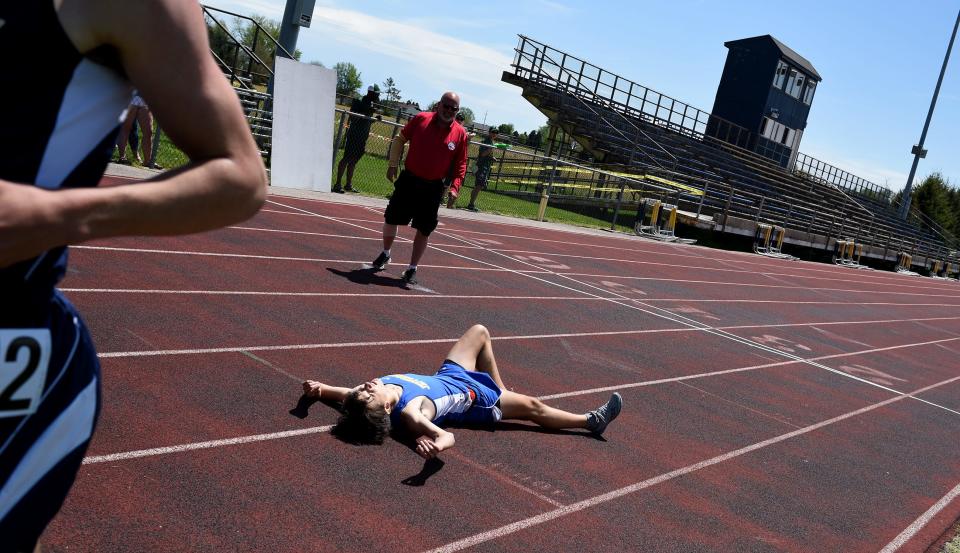 Carter McCalister of Monroe Jefferson fell after leaning so far at the finish line just loosing to Jackson Ansel of Erie Mason in the 1600 meter run at the Mason Invitational Saturday.